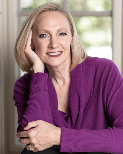 A woman in purple shirt posing for the camera.